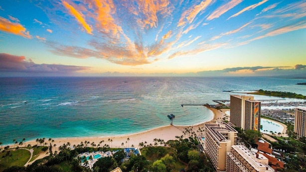 A coastal resort with a beach, a pool area, and high-rise buildings. - 1BR Plus Partial Ocean View – Grand Islander Waikiki Escape (Honolulu)