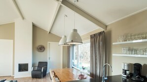 Een moderne keuken met een houten eettafel, een inbouwspoelbak en een raam met gordijnen.