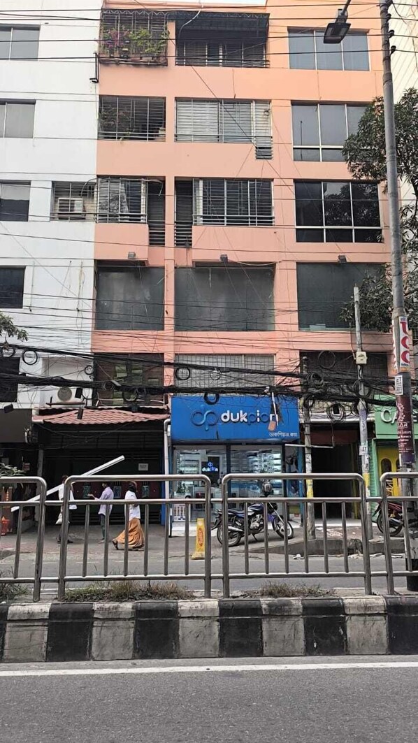 Un edificio de varios pisos con una tienda en la planta baja que dice 'dukpiar'.