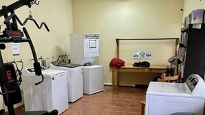 Een wasserette met een wasmachine, droger en een compleet fitnesscentrum.