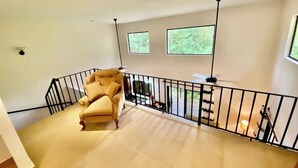 A spacious room with a high ceiling, a large window, and a balcony with a railing. - Villa 9B Toucan Valley Jungle Village Resort (Ciudad Cortés)