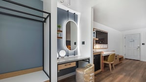 A modern bedroom with a bed, bedside table, and a large mirror.