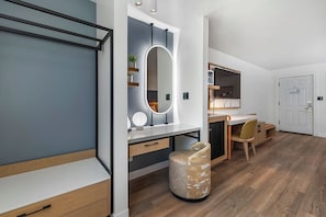 Un dormitorio moderno con cama, mesita de noche y un espejo grande.
