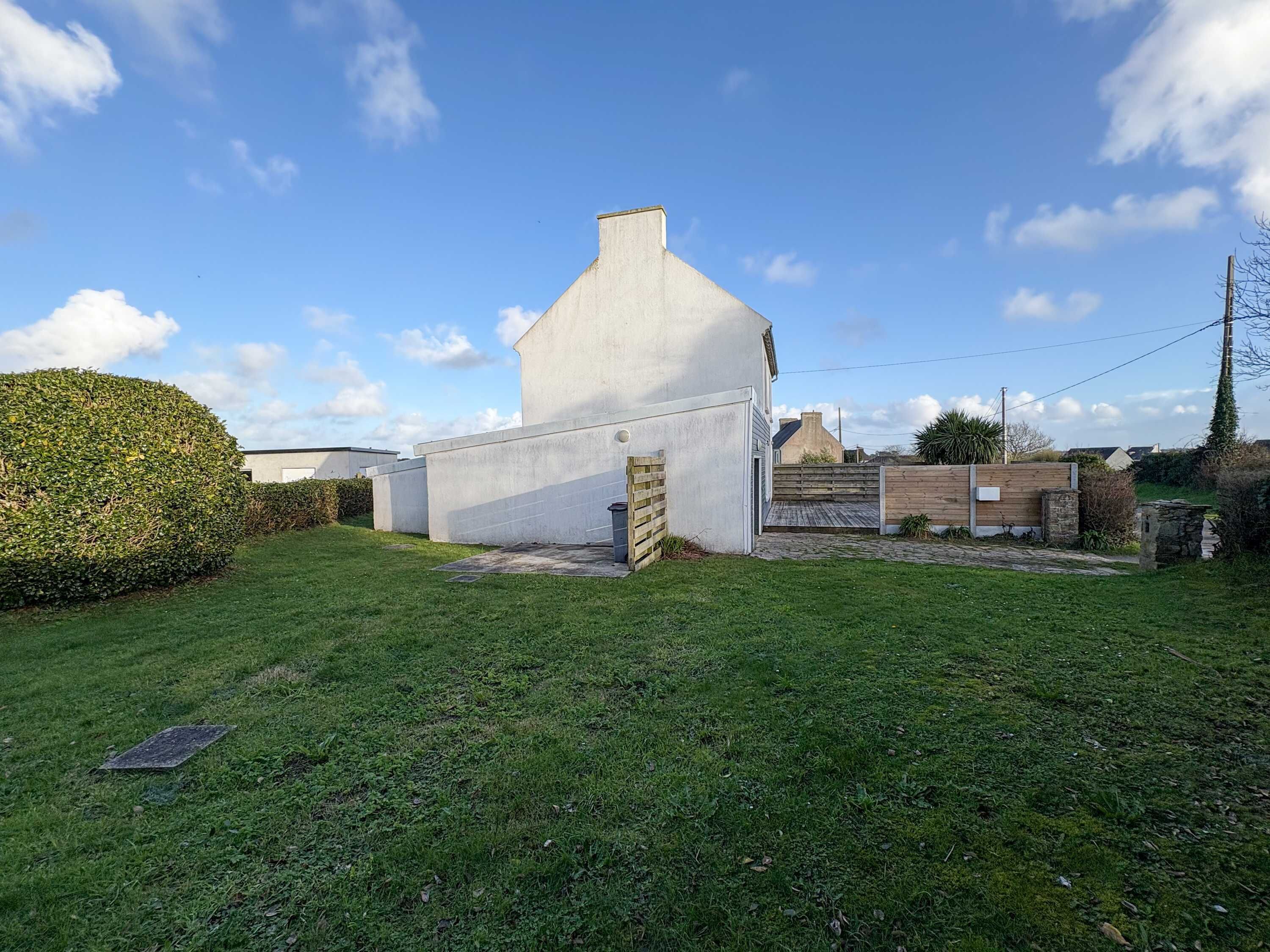 Un bâtiment moderne doté d’un toit plat, d’un petit garage attenant et d’une pelouse bien entretenue.