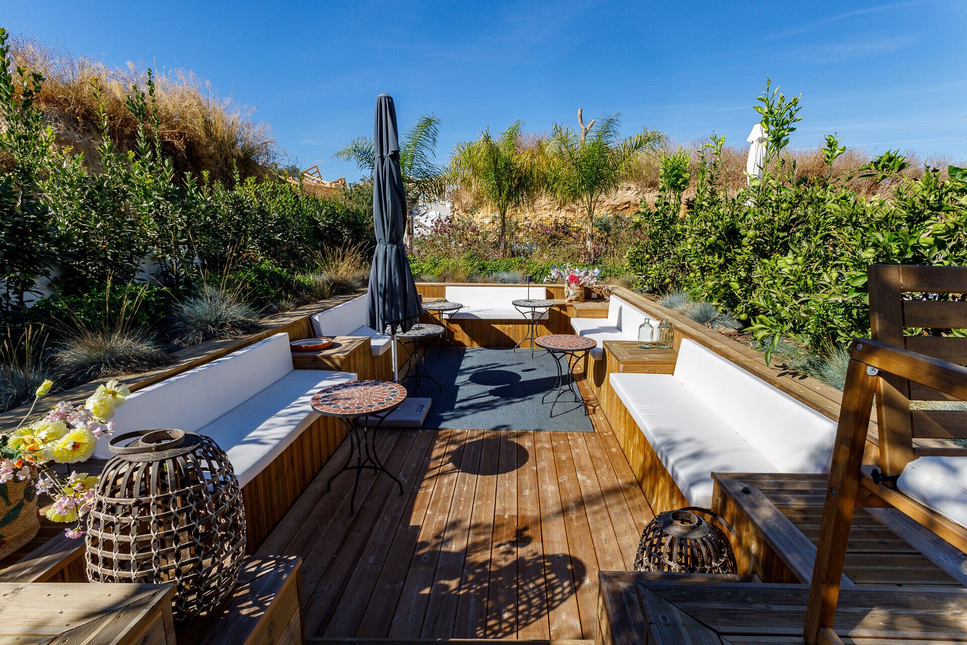 Une terrasse extérieure avec des meubles en bois, une table couverte et une lanterne décorative.