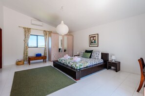 A bedroom with a bed, bedside table, nightstand, and a window with curtains. - Casa no Limoeiro, Stylish Retreat (Loulé)