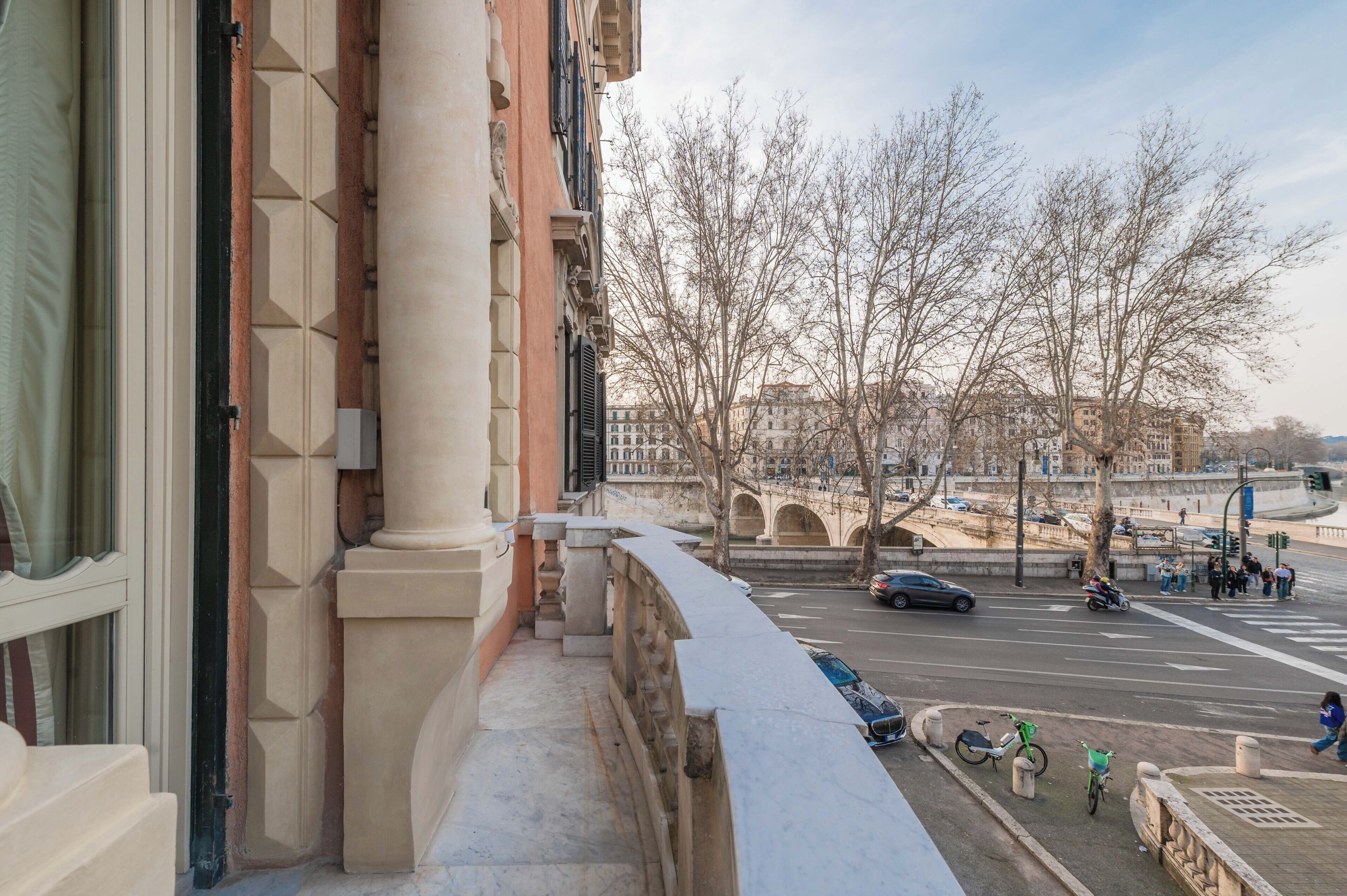 A balcony with a view of a city street, a bridge, and buildings.