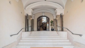 A grand staircase with white marble steps and black handrails, leading to a doorway framed by white columns. - Vista Ara Pacis, lussuoso appartamento centro di Roma 5 min da Piazza di Spagna (Roma)