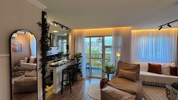 Ein modernes Wohnzimmer mit einer Couch, einem Essbereich mit Bar und einem großen Fenster mit Blick.