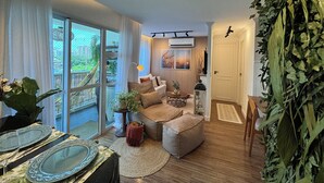 Ein modernes Wohnzimmer mit Sofa, Couchtisch und Blick ins Freie.