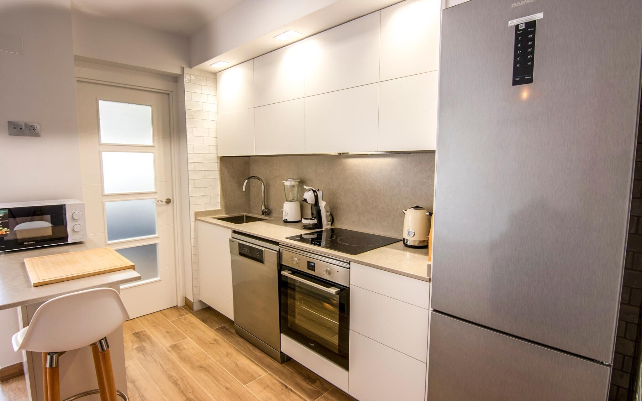 A modern kitchen with a microwave, stove, sink, and dishwasher.