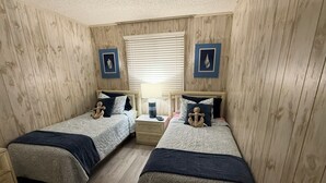 A room with two beds, wooden walls, and a window with blinds. - NEWLY LISTED! Oceanfront and BREATHTAKING views! 3 bedrooms (North Myrtle Beach)
