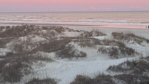 A beach with sand dunes and a calm sea under a pink sky. - NEWLY LISTED! Oceanfront and BREATHTAKING views! 3 bedrooms (North Myrtle Beach)