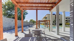 A covered outdoor area with a pool, lounge chairs, and tables. - Pacific coast retreat w/ kayak, bikes & pool (Tondoroque)