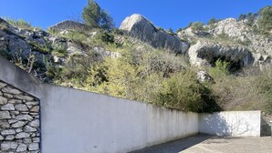 A paved area with a stone wall and a view of rocky terrain and trees. - Quiet studio at the foot of St Jacques hill,a stone's throw from the city center (Cavaillon)