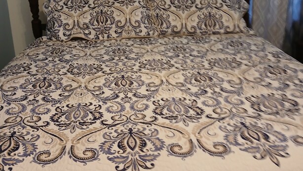 A bed with a patterned bedspread, a wooden headboard, and curtains. - - Love and Tranquility (Room E and Room C)  (Tampa)