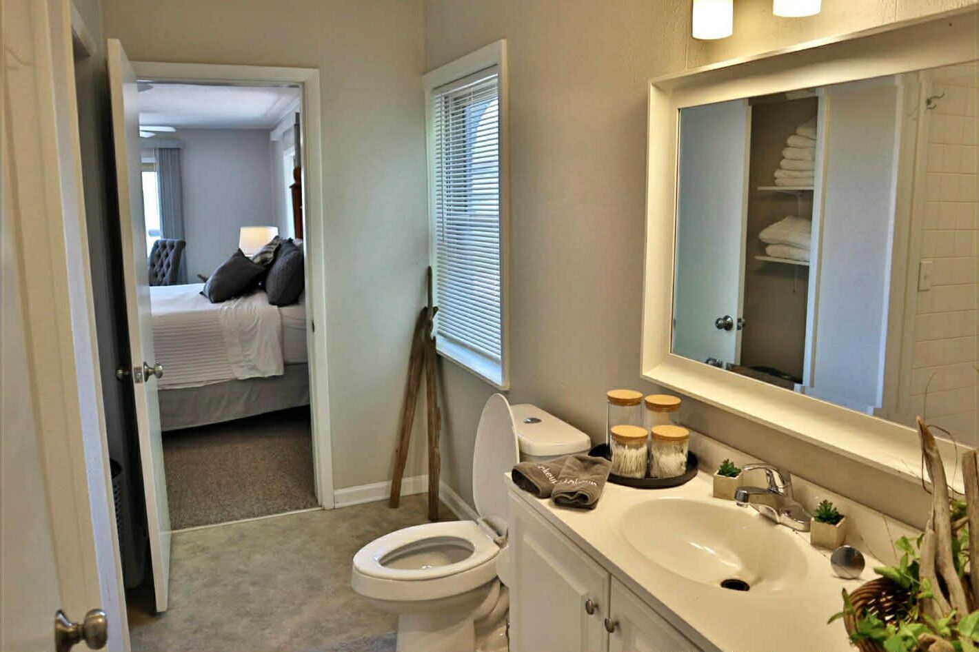 A bathroom with a toilet, sink, and mirror.
