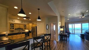 A spacious kitchen with wooden cabinets, a central island, and pendant lighting.