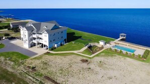 A large, multi-story building with a pool and a beach view.