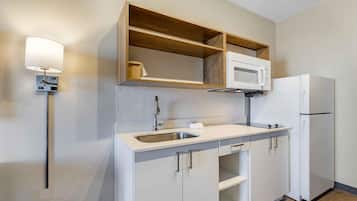 Una cocina moderna con microondas integrado, un fregadero y un refrigerador.