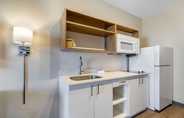 A modern kitchen with a built-in microwave, a sink, and a refrigerator.