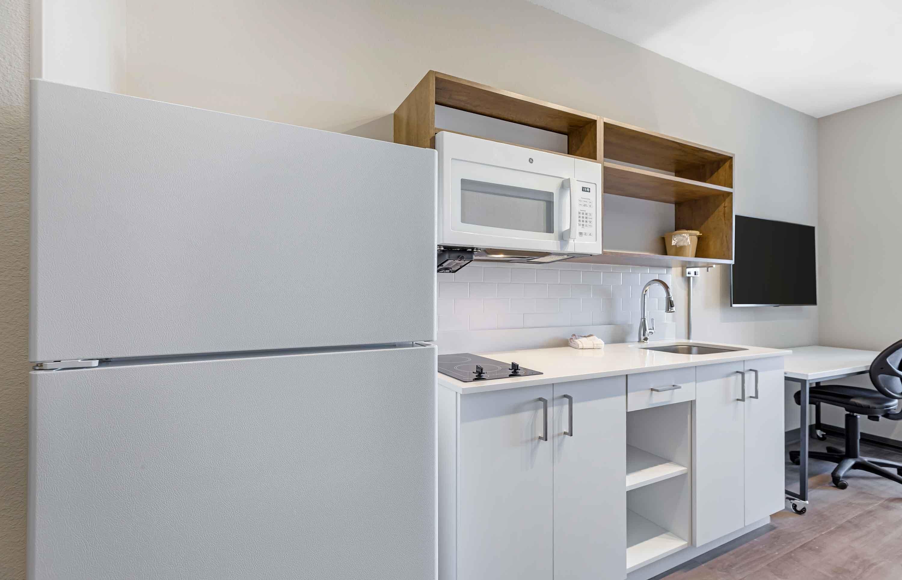 A compact kitchen with a built-in microwave, a sink, and a small countertop.