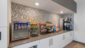 A kitchenette with a coffee machine, a refrigerator, and various food items on the counter. - Extended Stay America Premier Suites - Denver International Airport (Denver)