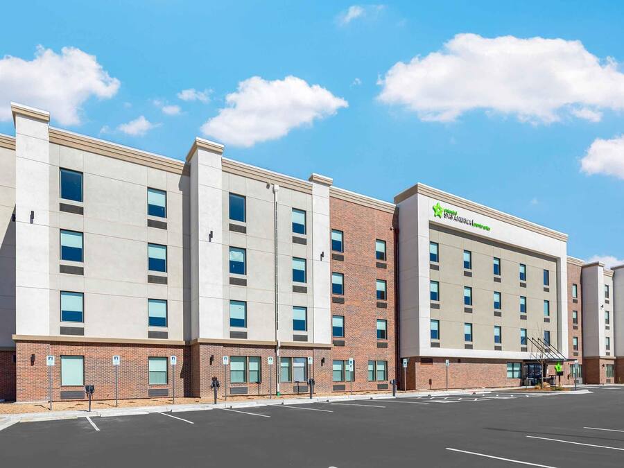 A multi-story hotel with a brick facade, large windows, and a clear sky.
