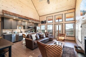A spacious cabin interior with a kitchen, dining area, and seating area. - Indoor Pool Cabin / Hot Tub / Close to Dollywood / Stay three & Play for Free (Sevierville)