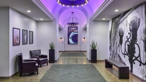 A lobby with a reception desk, seating area, and a large wall mural.