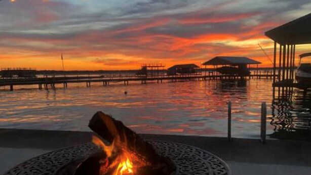 A sunset view with a fire pit and overwater structures.