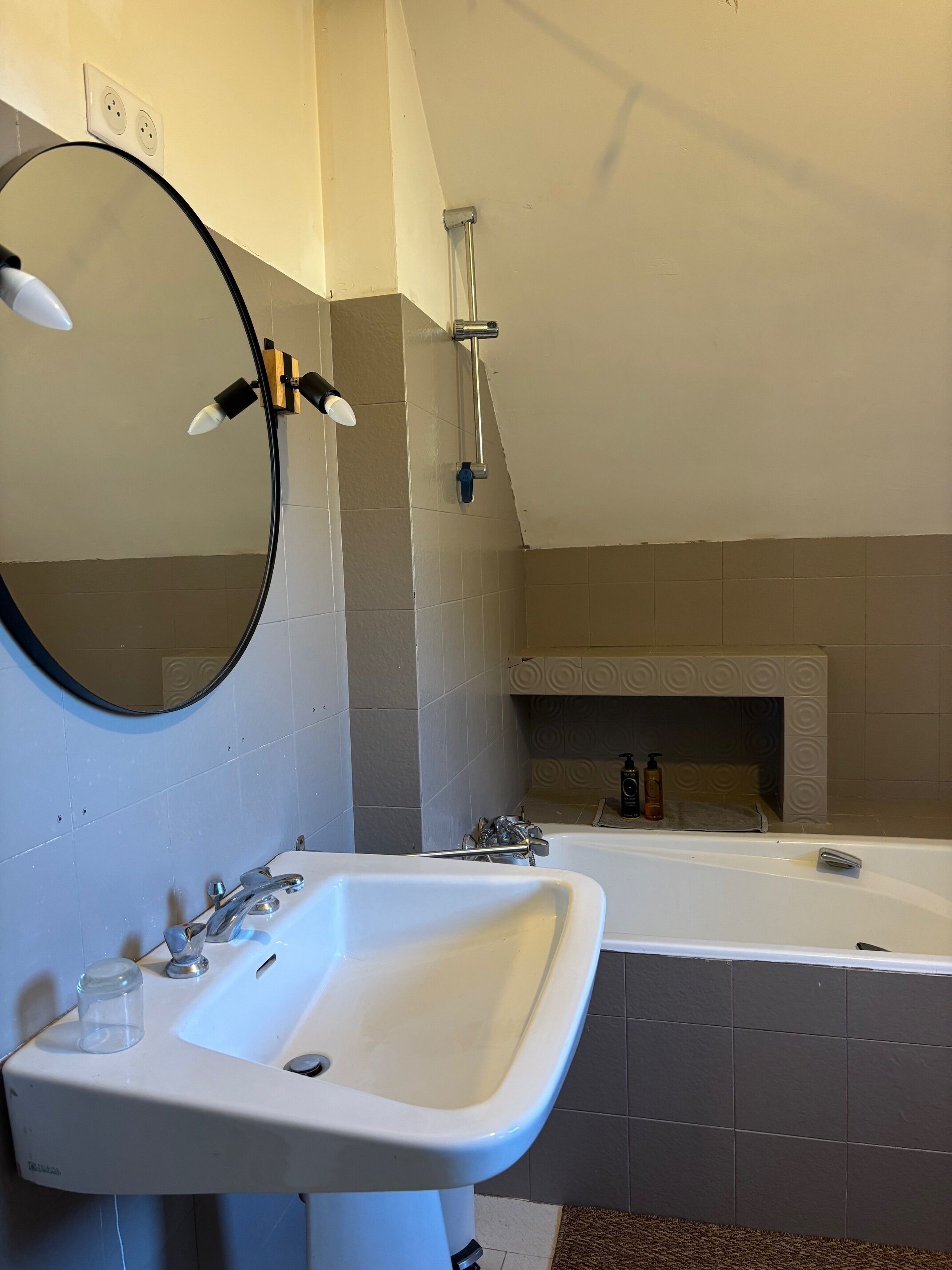 A bathroom with a sink, mirror, shower, and bathtub.