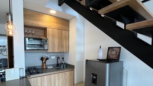 Una cucina moderna con mobili in legno, forno integrato e frigorifero in acciaio inossidabile.