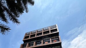 A multi-story building with balconies, a storefront, and a parked motorcycle. - Affordable accommodation with terrace in Medellín - LOF (Medellín)