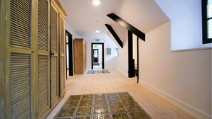 A hallway with wooden doors, a tiled floor, and a staircase leading to a landing. - Lovely home in Spa with sauna (Spa)