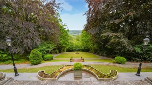 A formal garden with a central fountain, symmetrical pathways, and lamp posts. - Lovely home in Spa with sauna (Spa)