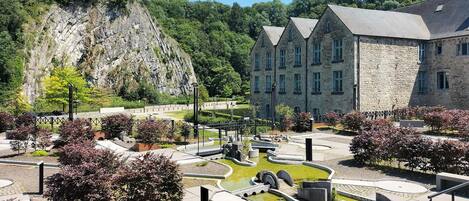 A stone building with a garden and a pond.