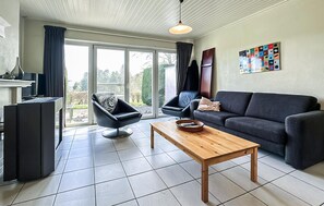 A modern living room with a sofa, armchair, and coffee table. - 2 bedroom nice home in Rendeux (Rendeux)