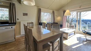 Eine moderne Küche mit Essbereich, großen Fenstern und Blick ins Freie.