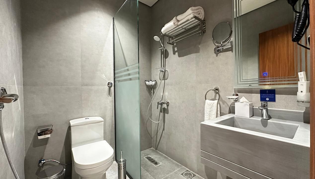 Combined shower/bathtub, hair dryer, slippers, towels