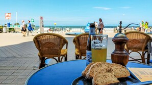 Ein Tisch mit einer Flasche Blanche de Narbonne, einem Brot und einem Gewürzmühlenaufsatz.