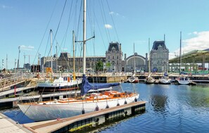 A marina with boats docked, a bridge, and a large building with a green roof in the background. - Gorgeous apartment in Oostende with WiFi (Oostende)