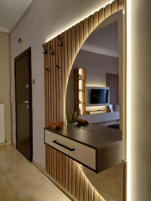 A modern bathroom with a vanity, mirror, and towel rack. - Maison Centrale Apartment in the Heart of Serres (Serres)