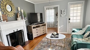 Uma sala de estar com lareira, televisão, sof á e mesa de centro.