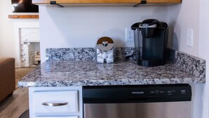 Une cuisine équipée d’une machine à café, d’un égouttoir et d’un four à micro-ondes.