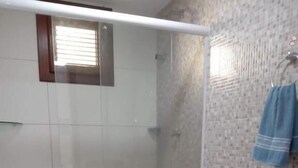 A bathroom with a shower, two toilets, a sink, and a mirror. - Hostel Aldeia Inn (Fortaleza)