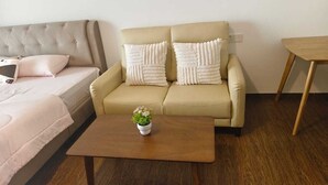 Un salon avec un canapé, une table basse et une petite plante.