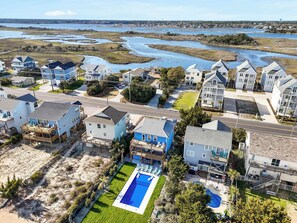 A residential area with houses, a swimming pool, and a view of a water body. - Pirates & Paradise: Private Pool, Home Theatre, and Pet Friendly (Surf City)