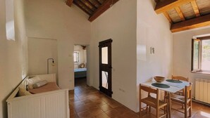 A room with a bed, a dining table with chairs, a window, and a door. - Casale Milleluci - apartment with a view of the hills 10 min from the sea (SENIGALLIA)