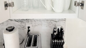 A kitchen with a toaster, a knife block, and a paper towel holder. - New 2BR/2BA LUXE Harvard & MIT w/Parking Red Line (Somerville)